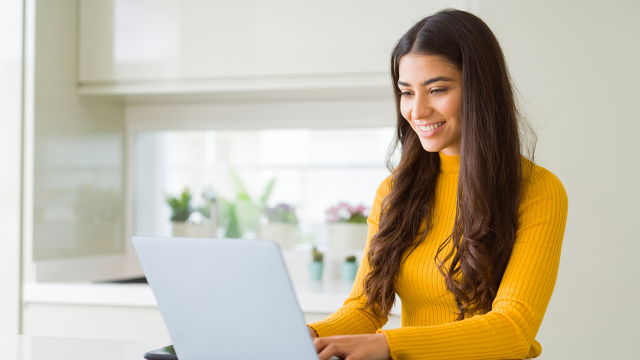 Woman in yellow shirt working on computer